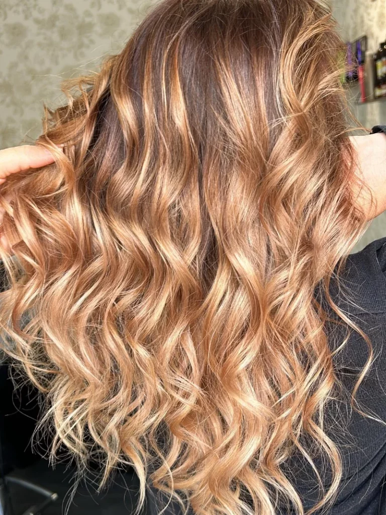 Client aux cheveux longs avec coloration et mèches, coiffage wavy réalisé en salon par Mademoiselle S Coiffeuse Visagiste, pour un résultat naturel et lumineux.