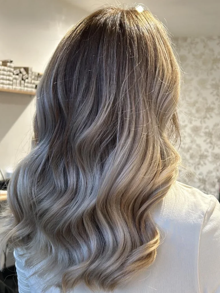 Client aux cheveux longs avec coloration et mèches, coiffage wavy réalisé en salon par Mademoiselle S Coiffeuse Visagiste, pour un résultat naturel et lumineux.